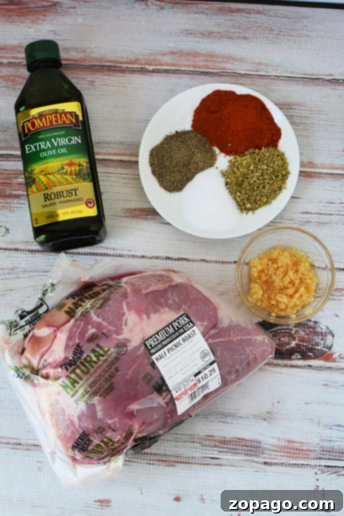 Oven Roasted Pork 3 Pork picnic Roast Recipe, with a bottle of olive oil, minced garlic, and a plate of herbs and spices on a white wood surface—perfect ingredients before roasting in the oven.