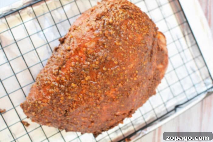 Oven Roasted Pork 7 Seasoned ham on a wire rack over a foil-lined baking sheet, prepared just like a classic pork roast recipe, ready for the oven.