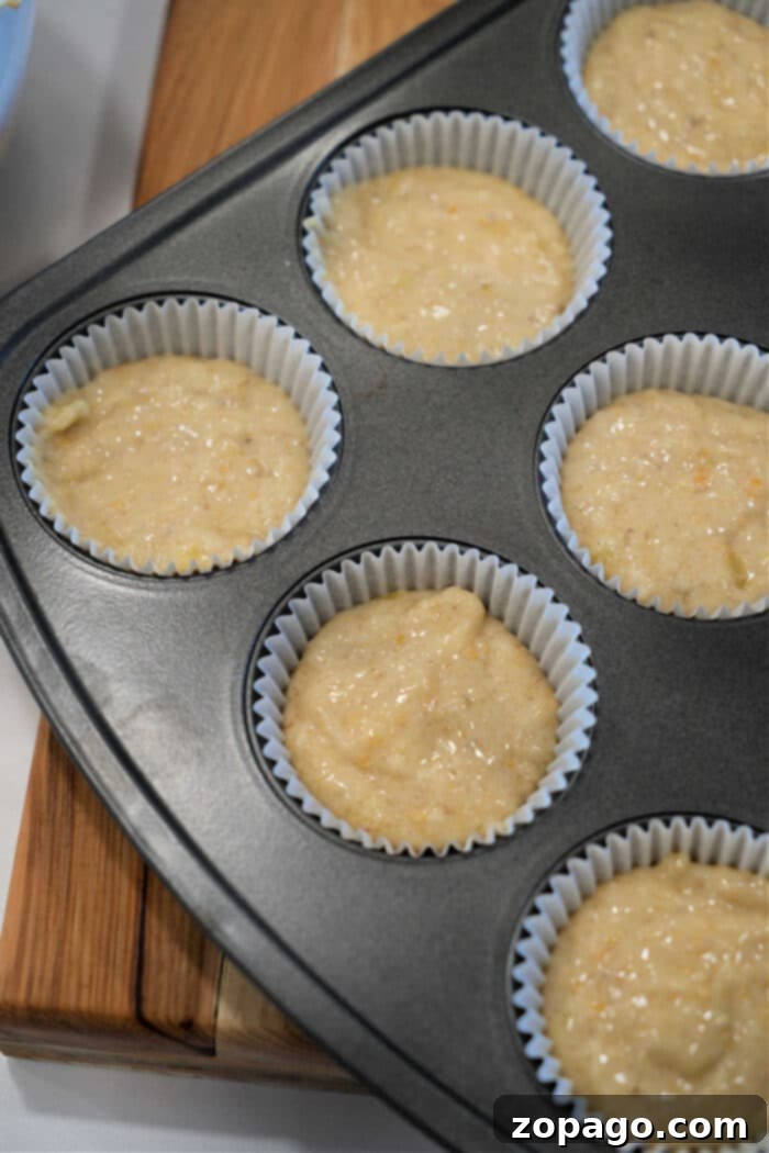 Moist Banana Muffins 3 Banana muffin batter in paper liners inside a muffin tin, ready to be baked—perfect for trying out your favorite Banana Muffin Recipe.