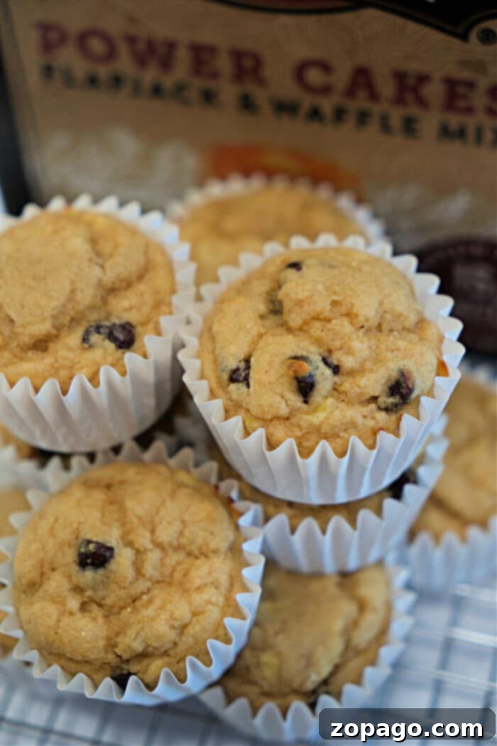 Power-Packed Kodiak Banana Muffins 5 A stack of Kodiak Muffins in white paper liners sits in front of a box of pancake mix, tempting you with every chocolate chip.