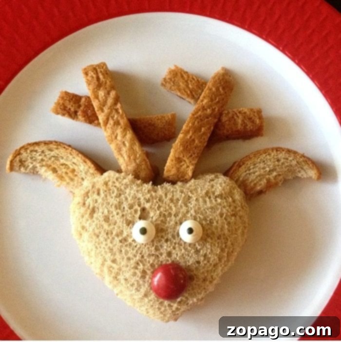 Reindeer Sandwich A cute reindeer sandwich made with peanut butter, bread crust antlers, candy eyes, and a red nose, perfect for holiday snacks.
