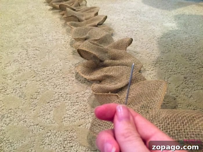 Gathering Burlap Garland Burlap being gathered along the craft wire, secured by a pen jar.