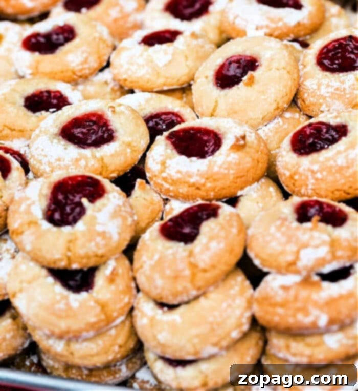 Golden Peanut Butter Thumbprints 2 Delicious Peanut Butter and Grape Jelly Thumbprint Cookies on a Cooling Rack