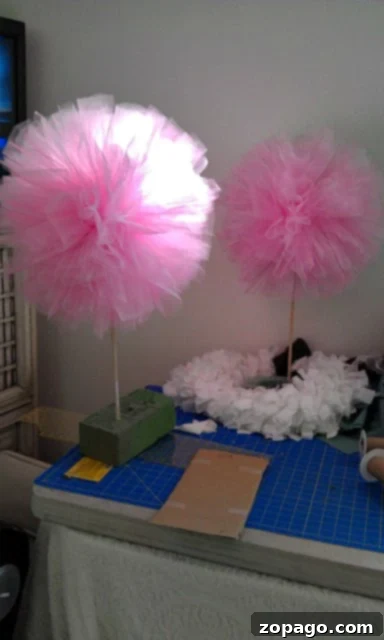 Charming DIY Baby Shower Decorations 3 Creating DIY baby shower centerpieces with tulle pom poms.