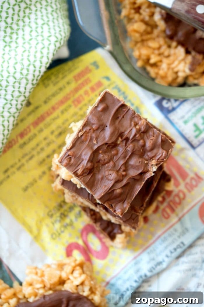 No bake recipe for Scotcheroos are the best peanut butter and butterscotch dessert recipe ever that has chocolate in it too. Super easy to make with cereal. Close-up of freshly made no-bake Scotcheroos showing the crunchy cereal base and the smooth peanut butter and butterscotch topping.