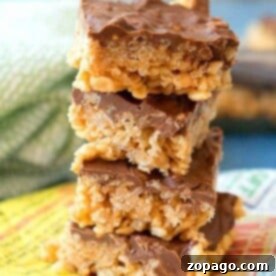 Golden Scotcheroo Squares 2 A delightful stack of chocolate-covered rice krispies treats sits on a colorful napkin, reminiscent of those irresistible scotcheroos.