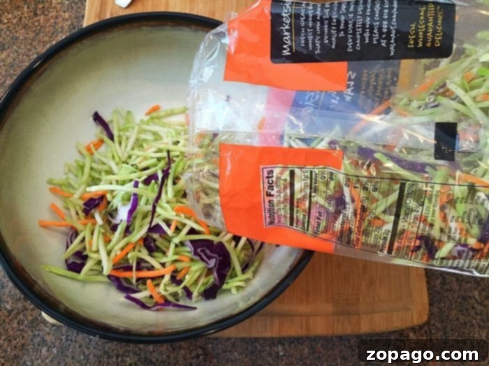 Easy homemade coleslaw recipe for pulled pork. This simple side dish is perfect for barbecue, sandwiches, or as a refreshing accompaniment to any meal. #coleslaw #homemade #easy #pulledpork A vibrant bowl of homemade coleslaw with crisp cabbage and carrots, ready to be served as a fresh side dish or on top of pulled pork sandwiches.