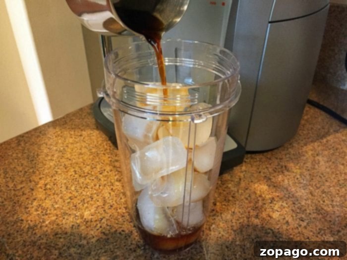 This is how to make a peppermint frappuccino at home with just 3 ingredients! Easy recipe to make a copycat Starbucks frappuccino at home. #peppermint #frappuccino The process of blending a homemade peppermint frappuccino in a high-speed personal blender, showing the creamy texture beginning to form. This step highlights the ease and speed of creating a Starbucks-quality drink in your own kitchen.