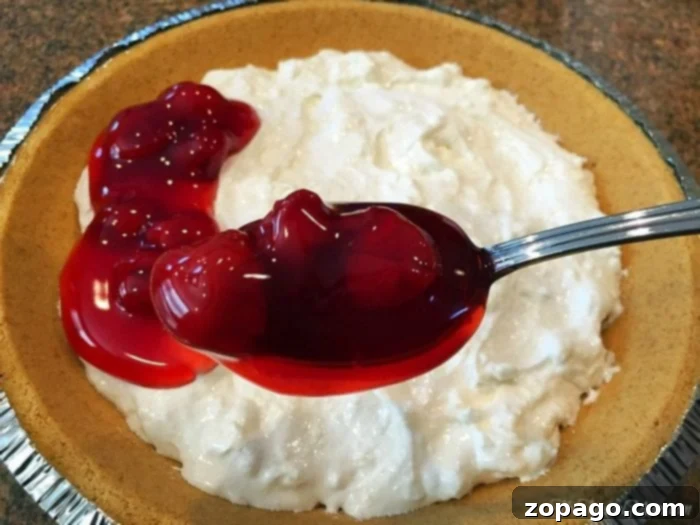 Cherry Cheesecake Delight 4 Cream cheese dip with a spoon, highlighting its smooth and creamy texture.