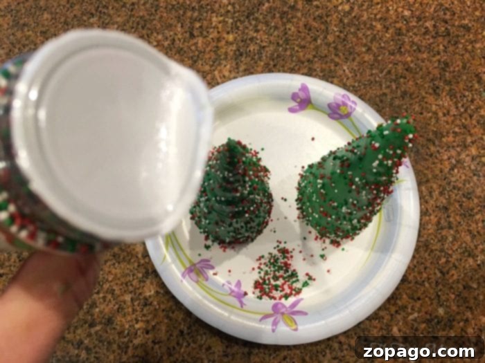 Watch as sugar cones transform into festive Christmas trees with melted chocolate and colorful sprinkles. Sugar cones being dipped in green melted chocolate and decorated with sprinkles
