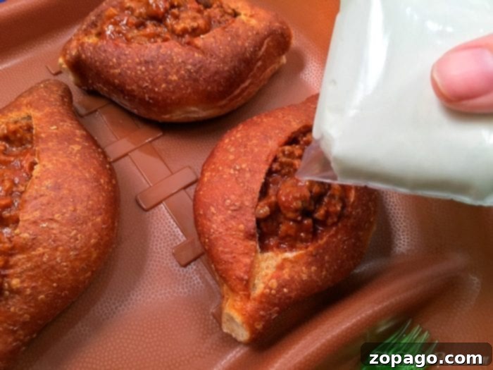 Sloppy Joe bread bowls are great for a football appetizer or any other party you're having! EASY to make and delicious! #football #sloppyjoes #superbowl #appetizer #breadbowls Football appetizer: Sloppy Joe Bread Bowls with sour cream laces