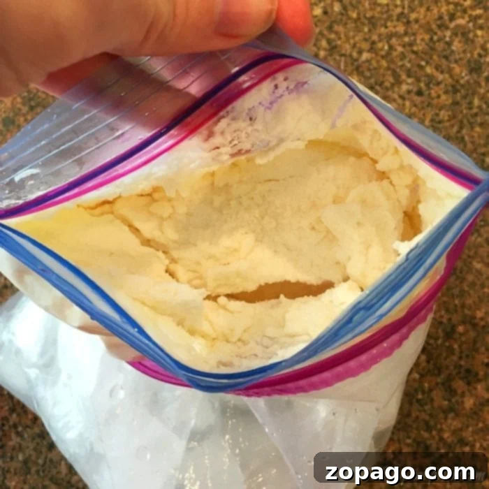 Child eating homemade ice cream from a bowl, proud of their ice cream in a bag creation.