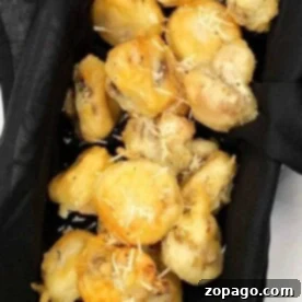 Tempura mushrooms, delicately fried to perfection and garnished with a sprinkle of grated cheese, rest elegantly on a black cloth.