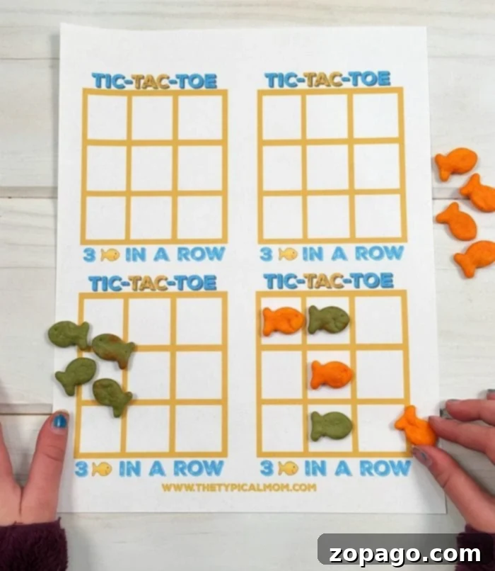 Goldfish crackers games like this fish tic tac toe game using different colors of Goldfish is fun to play! Great treats you can make with your kids as well as a game you can play with cheesy Goldfish crackers they all love! #freeprintable #printable #goldfish #games #tictactoe #game #fish Goldfish game in action