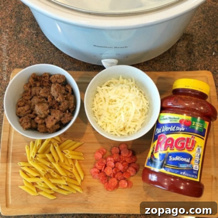 This slow cooker pizza casserole recipe is amazing! So easy to make in your crockpot and great for dinner or a party with kids. #slowcooker #pizza #crockpot #casserole #crockpotrecipes #thetypicalmom Ingredients for slow cooker pizza casserole: penne, cooked sausage, shredded cheese, mini pepperoni, and a jar of sauce.