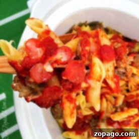 Close-up of a slow cooker pizza casserole featuring baked penne with tomato sauce, pepperoni, and melted cheese in a white dish.