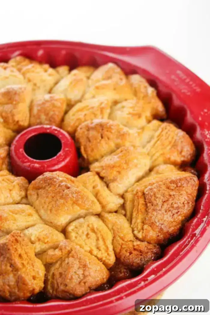 Easy monkey bread recipe using refrigerated biscuits is easier than you think! Add apples, berries and a drizzle of frosting for the ultimate breakfast. #monkeybread #biscuit #pillsbury #christmasbreakfast #breakfast #brunch #dessert #easy #basic #thetypicalmom A beautifully glazed Pillsbury monkey bread, ready to be pulled apart and enjoyed.