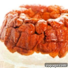 Monkey bread with a glossy caramelized glaze sits enticingly on a decorative glass plate.