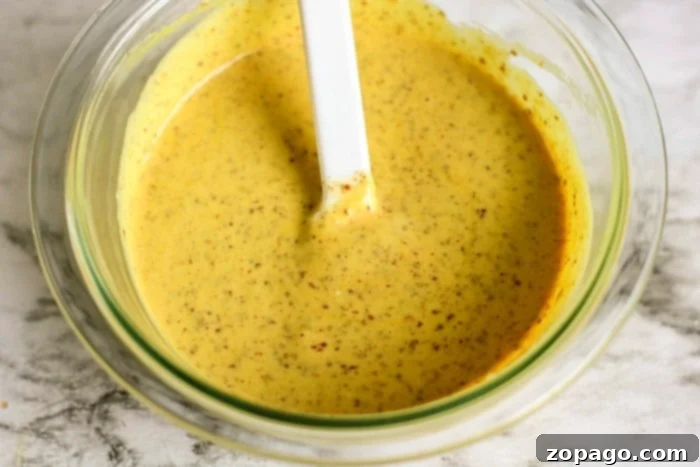 Sizzling Hot Dips 5 Pretzel dipping sauce in a small white bowl with soft pretzels.