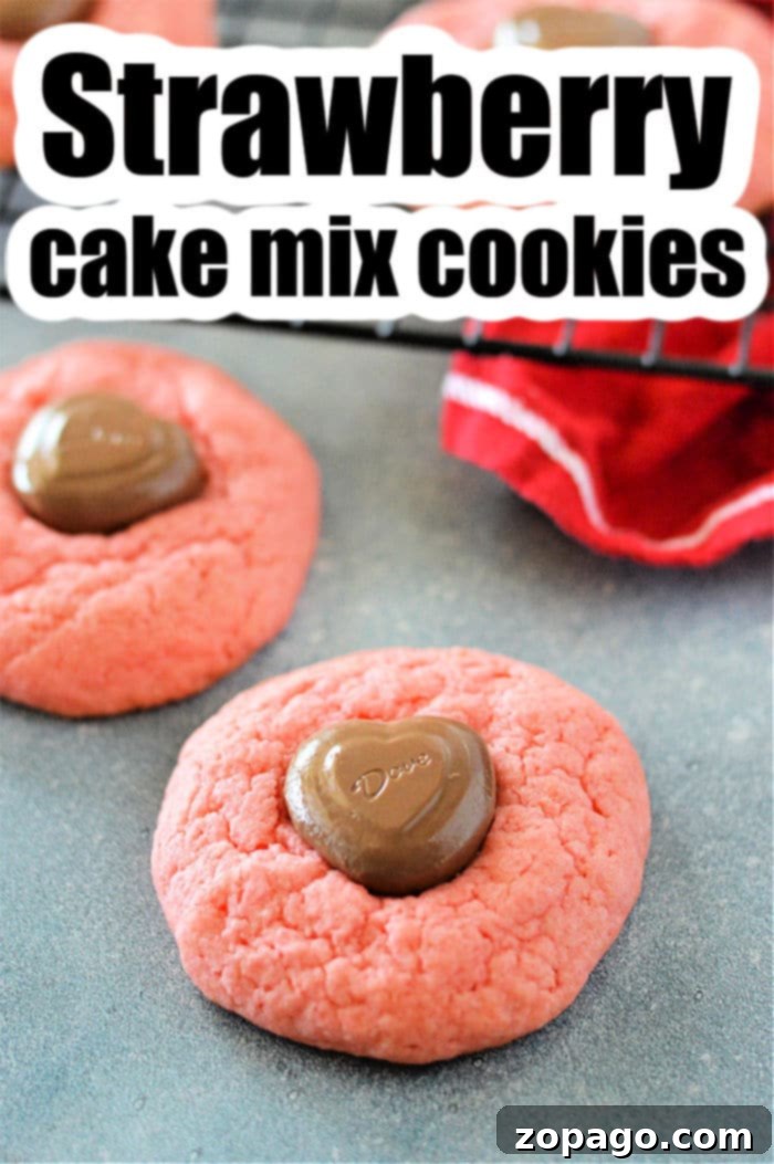 Easy Strawberry Cake Mix Cookies 2 Close-up of baked strawberry cake mix cookies on a baking sheet, some topped with chocolate hearts.