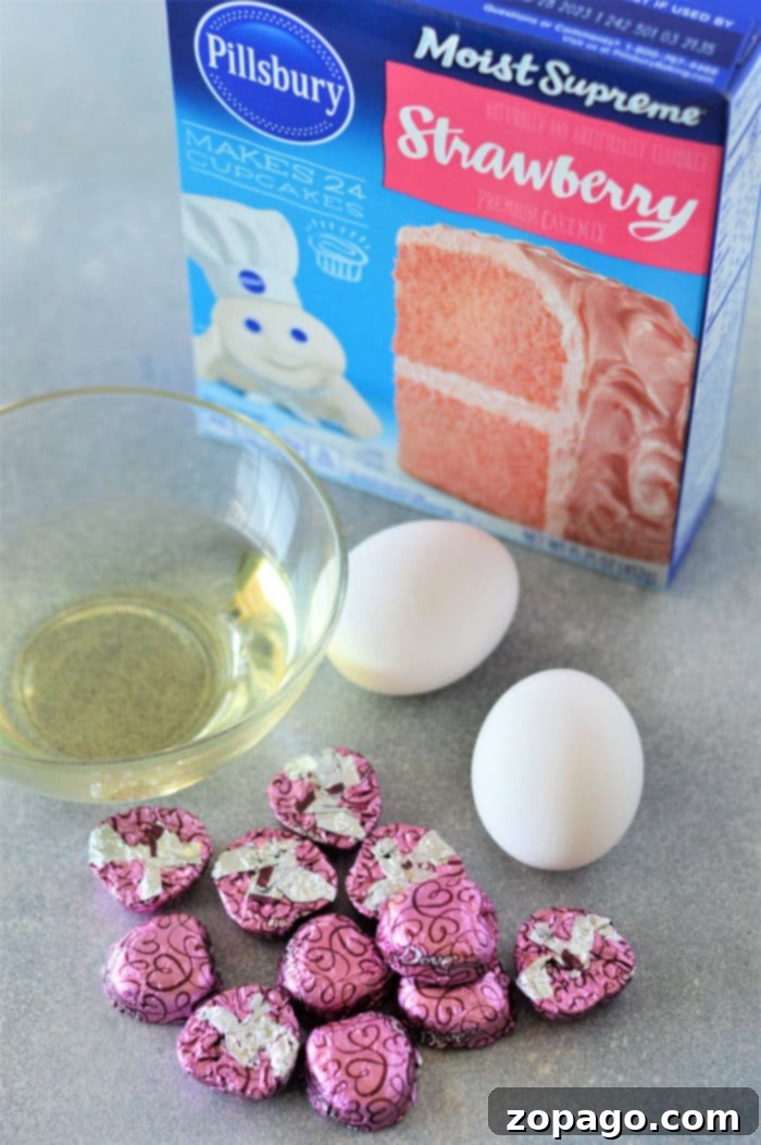 Easy Strawberry Cake Mix Cookies 3 Ingredients laid out for making strawberry cake mix cookies: cake mix box, eggs, and vegetable oil.