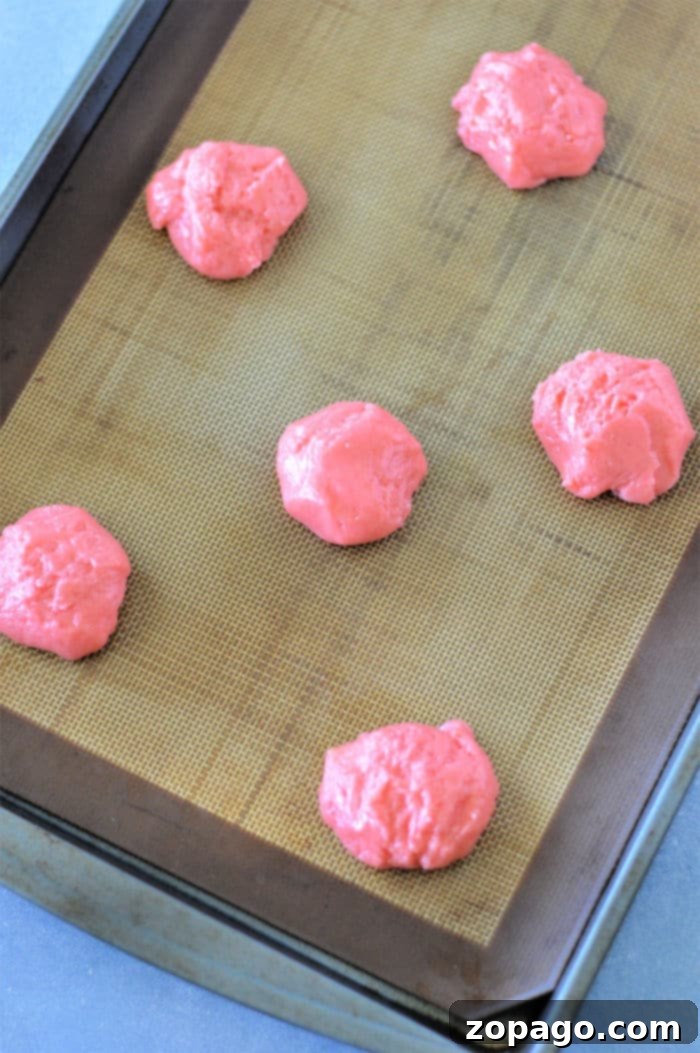 Easy Strawberry Cake Mix Cookies 6 Close-up of a single pink strawberry cookie with a small chocolate heart on top.