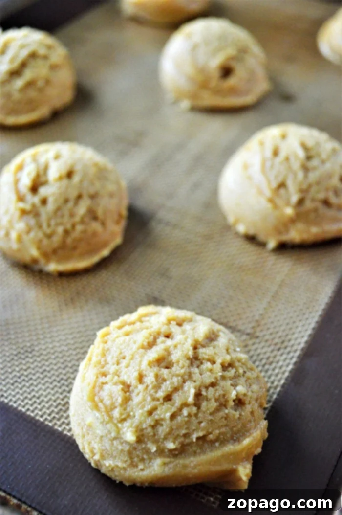 Effortless Cake Mix Cookies 6 A close-up shot of freshly baked, soft cookies, still on the baking sheet, with a delicate golden hue.