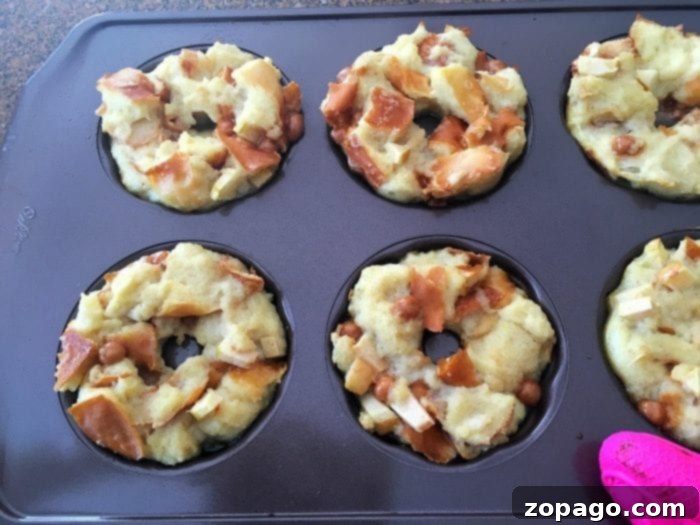 Spiced Caramel Apple Bread Pudding 6 A baking tray filled with six individual caramel apple bread puddings, each beautifully browned and moist, drizzled with caramel sauce.