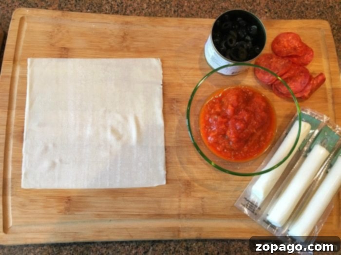 Crispy Pizza Bites 3 Cooked pizza egg rolls, golden brown and crispy, cooling on a rack.