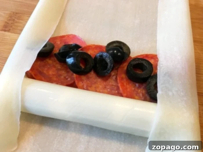 Crispy Pizza Bites 4 Crispy golden brown pizza egg rolls cooling on a wire rack after being perfectly deep-fried, ready to be served as a delicious snack or appetizer.