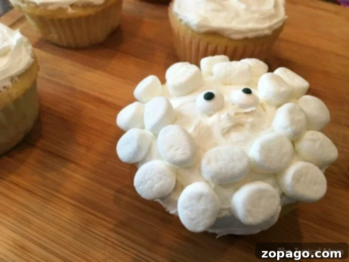 Adorable sheep cupcakes with marshmallow wool and candy eyes, perfect for Easter, baby showers, or birthday parties. Charming sheep cupcakes, adorned with white frosting and mini marshmallows to perfectly mimic a sheep's face, rest delightfully on a wooden surface, ready for celebration.