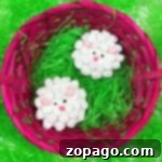 A close-up of a finished sheep cupcake, showing the soft marshmallow wool, candy eyes, and pink nose, perfect for a themed party or holiday.