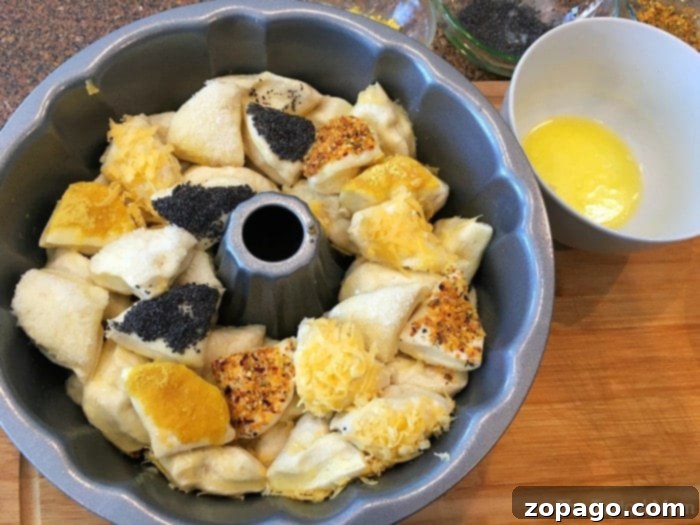 Savory monkey bread is the best along side pasta!! Super easy to make and looks beautiful as an appetizer or side dish or any occasion. #savory #monkeybread A baked savory monkey bread loaf, beautifully golden and ready to be served, on a white cake stand.