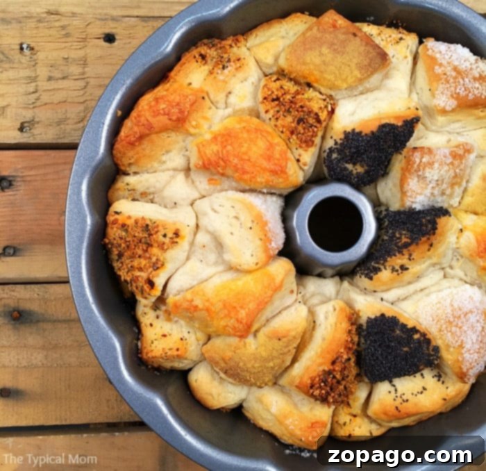 Savory monkey bread is the best along side pasta!! Super easy to make and looks beautiful as an appetizer or side dish or any occasion. #savory #monkeybread A close-up of a single piece of savory monkey bread being pulled apart, revealing its soft, cheesy interior.