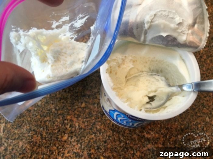 Fudgy Brownie Waffles 5 An open container of whipped topping with a spoon, next to a plastic bag filled with creamy goodness, ready to be used as a topping for brownie waffles on a granite countertop.