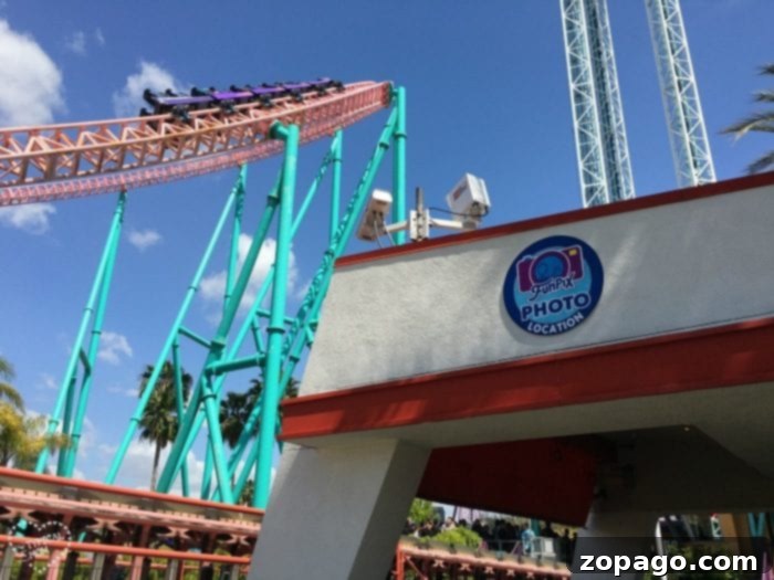 Knott's Berry Farm Photo Memories 4 A roller coaster ascending on a turquoise track at Knott's Berry Farm under a blue sky, with a building below proudly displaying a