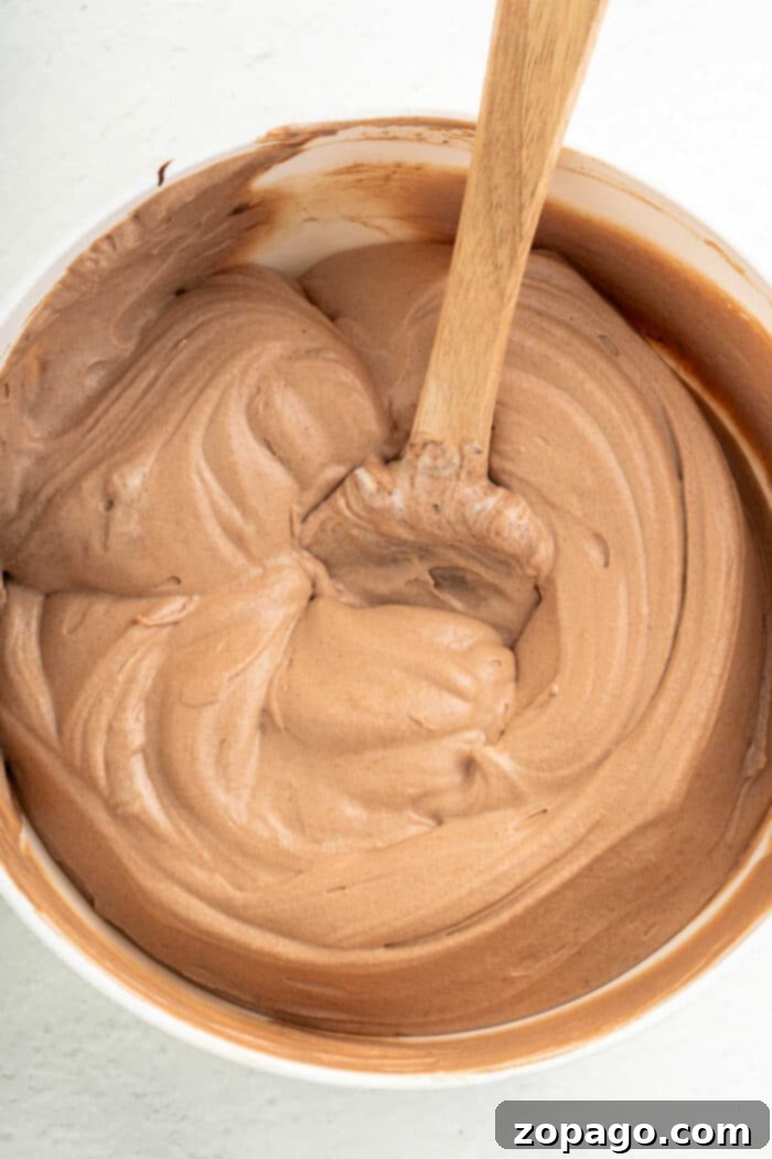 Espresso Frosting 5 A wooden spoon rests in a bowl of homemade creamy coffee frosting.