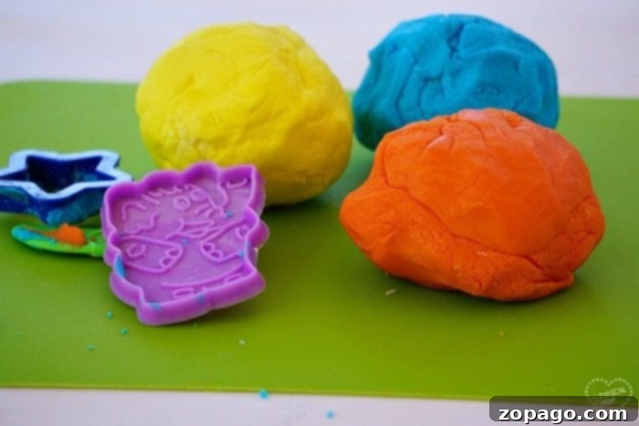 Easy 2 ingredient edible playdough that your kids will love! A simple playdoh recipe that is perfect for young children and fun to play with, even toddlers. #edible #playdough #playdoh #dough #craft #activity #rainyday #preschool #kindergarten #frosting Close up of edible playdough with ingredients and tools, showing the simple components for a fun activity.