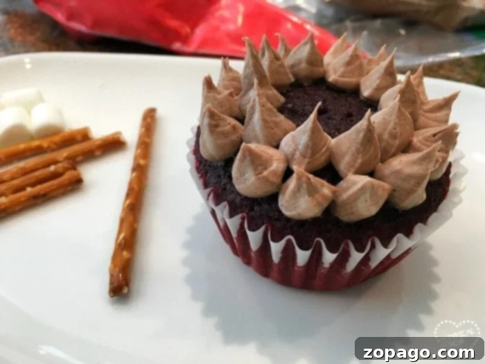 Happy Camper Cupcakes 4 Delicious campfire cupcakes arranged on a tray, featuring rich chocolate frosting, pretzel stick logs, and fiery red icing flames. Ready for a camping party or a sweet family treat.