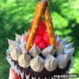 Camping cupcakes decorated as campfires, with pretzel sticks and red frosting.
