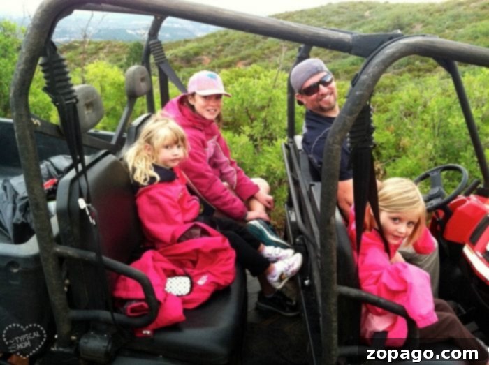 Travel for free with your kids year after year. We do this to get free vacations to National Parks and Disneyland too. Easy ways to travel for free, really! A family in an off-road vehicle exploring scenic dirt paths and hills, symbolizing ways to travel for free and experience adventure