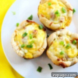 Hearty Ham and Cheese Biscuits 3 Three mini egg and cheese muffins topped with green onions grace a white plate, evoking the savory delight of ham and cheese biscuits, with a yellow napkin placed nearby.