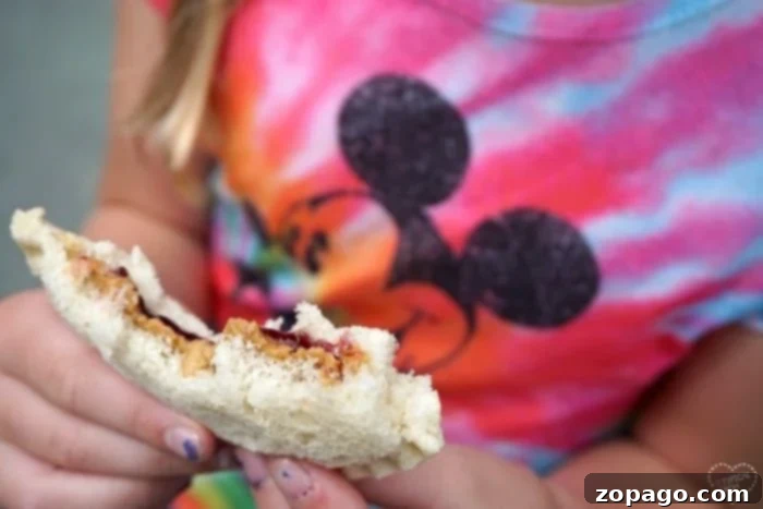 Essential Disneyland tips for families: from savvy dining to what to pack, ensuring a magical and budget-friendly trip. Family enjoying snacks, a key Disneyland tip for saving money and staying energized.