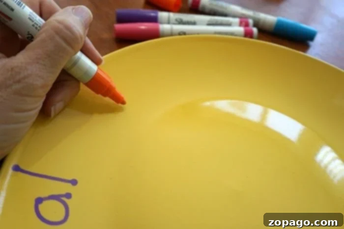 Create a 'You Are Special' Keepsake Plate 3 Close-up of a child adding whimsical designs to a yellow 'You Are Special' plate using Sharpie paint pens, demonstrating creative sharpie crafts.