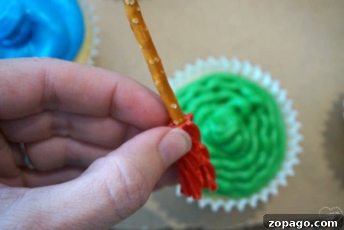 An art themed birthday party is perfect for boys and girls and inexpensive to put together! Here are a few fun party ideas including palette cupcakes, games, and art party favors that are perfect for artistic kids of all ages. #art #birthdayparty #party #activities #forkids #cheap #girl #boy A close-up shot of an art-themed party setup, featuring colorful frosted cupcakes arranged on a cardboard palette, ready for decorating, with a small edible brush beside them.