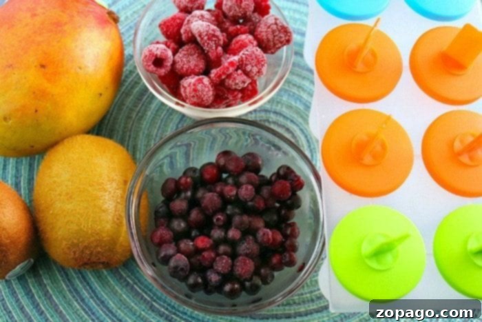 Vibrant Rainbow Fruit Pops 4 The process of making rainbow popsicles is illustrated with clear layers of colorful fruit puree in a mold, ready for freezing.