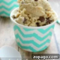 Easy Homemade Frozen Yogurt 3 A cup of chocolate chip cookie dough frozen yogurt sits on a wooden table, its zigzag pattern cup catching the eye—a tempting treat perfect for those curious about how to make frozen yogurt at home.