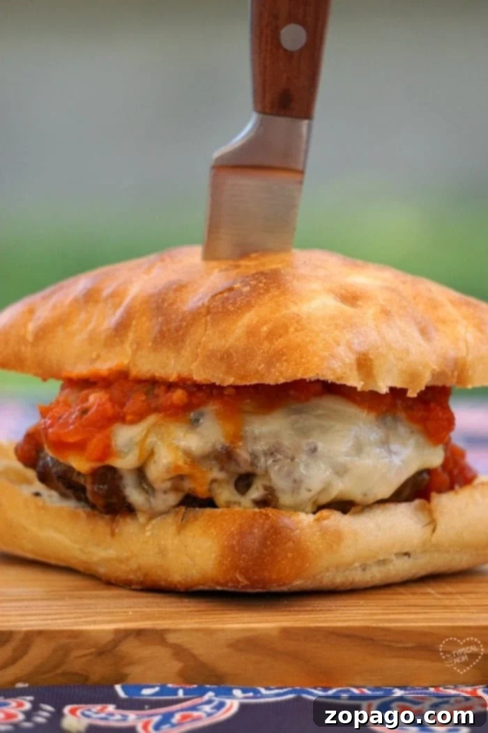 This New York pizza burger is the bomb!! Easy recipe that is to die for, the best burger ever! A tantalizing New York pizza burger, perfectly assembled and ready to be enjoyed, highlighting its cheesy, saucy, and perfectly cooked components.