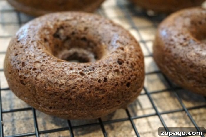 Cake mix donuts are so easy to make using any flavor of boxed cake mix you want! It's an easy baking project with your kids. #cakemix #donuts #doughnuts #dessert #bakingwithkids #dessert #breakfast A tray of various doughnuts made with cake mix, featuring different glazes and sprinkles, highlighting the ease and fun of homemade treats.