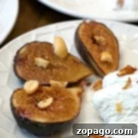Grilled figs with nuts and a scoop of vanilla ice cream on a white plate, reminiscent of learning how to bake figs in the oven for that perfect caramelized flavor.